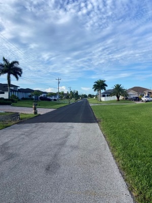 Photo of a road in the day that has been resurfaced a short distance away from the camera